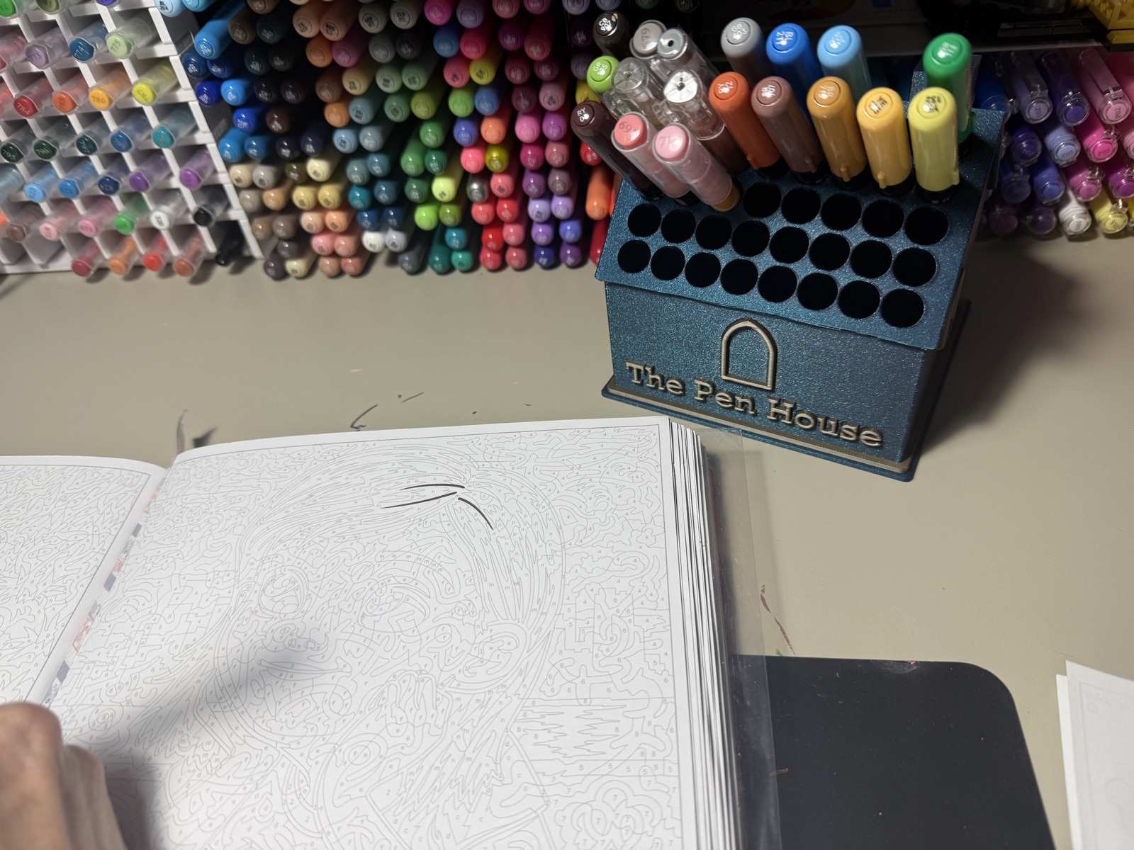 A galaxy blue Pen House full of markers on a craft desk